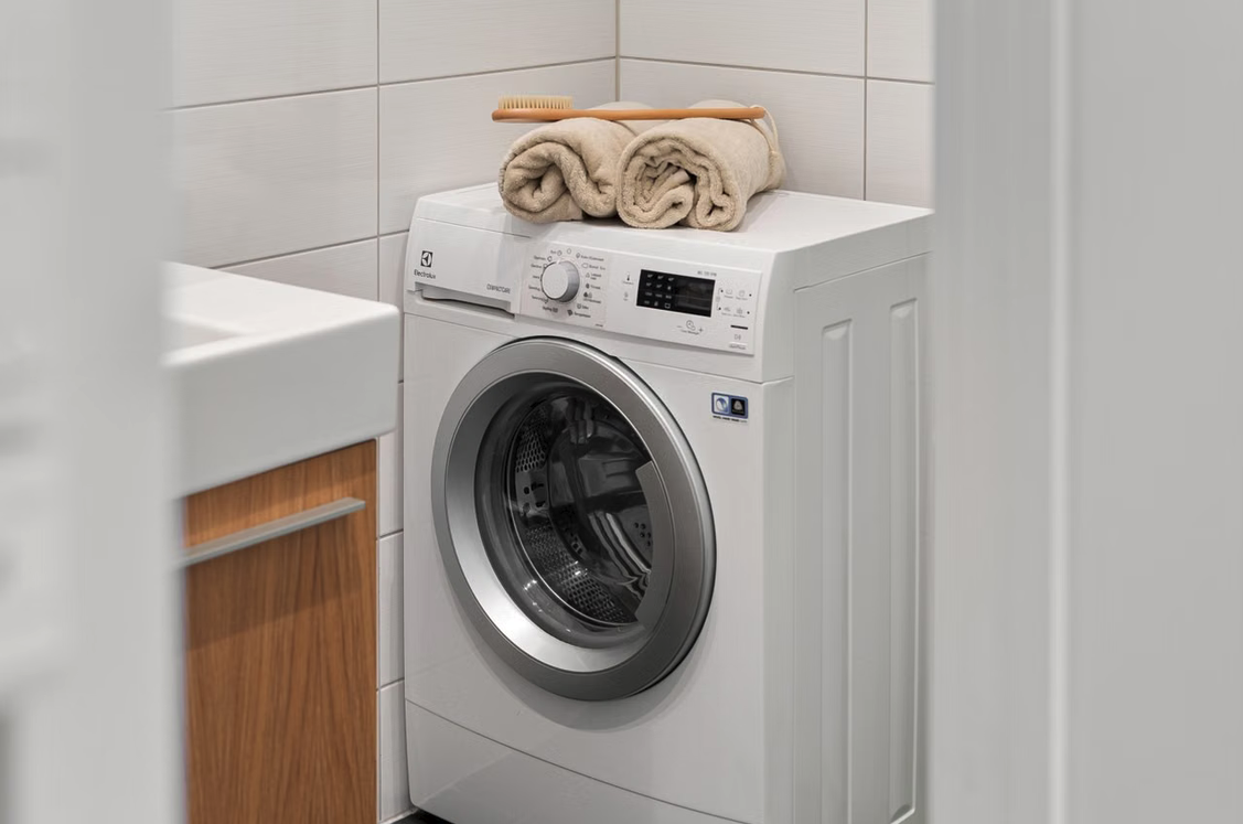 Waschmaschine mit Handtüchern oben drauf