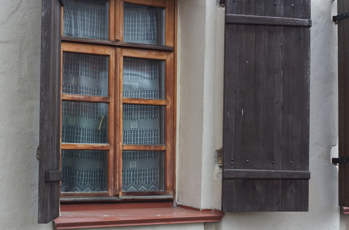 Holzfenster in einem Altbauhaus mit hölzernen Fensterläden.